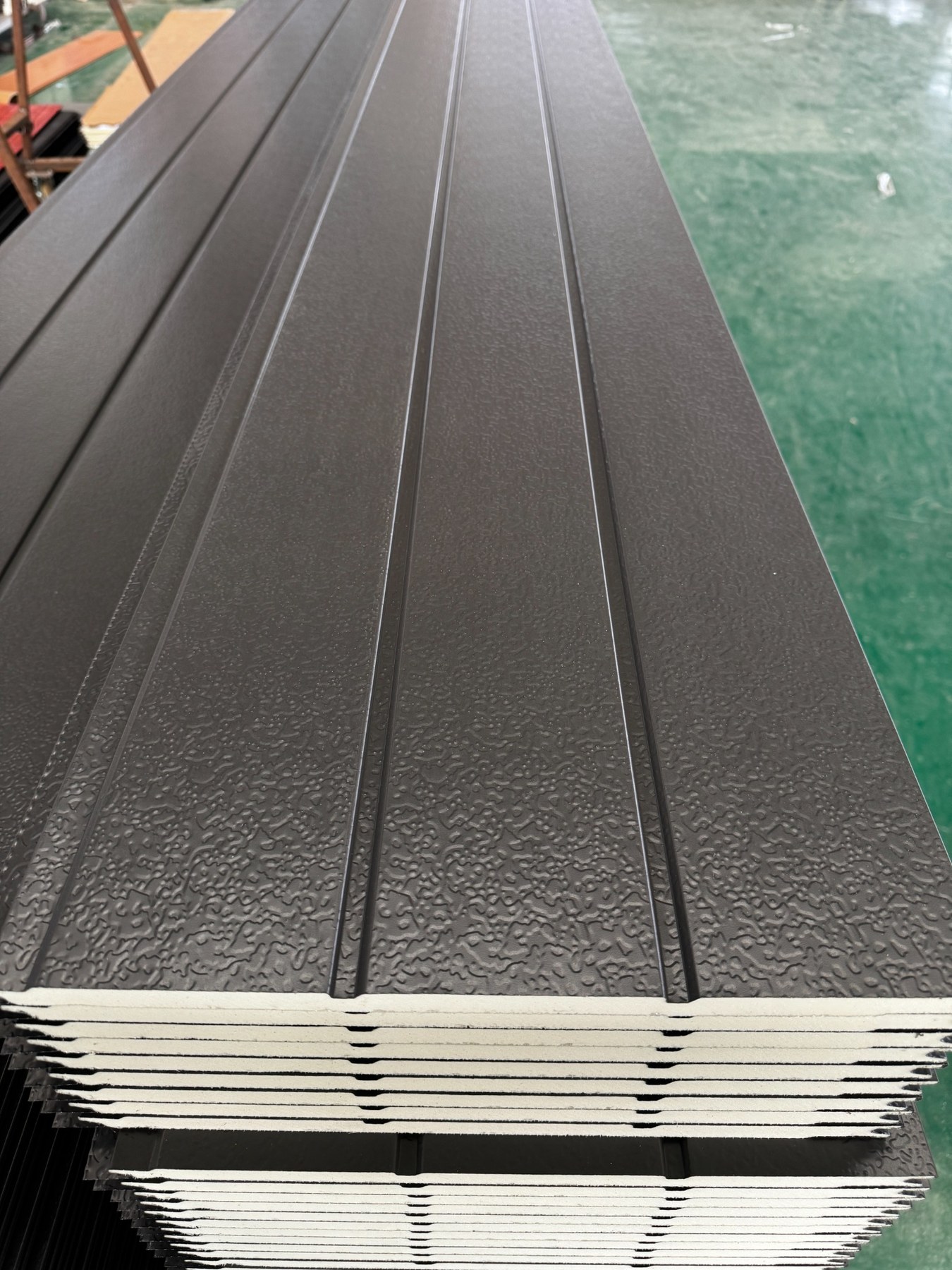 Stacked PU metal siding panels showing embossed steel surface and insulation core